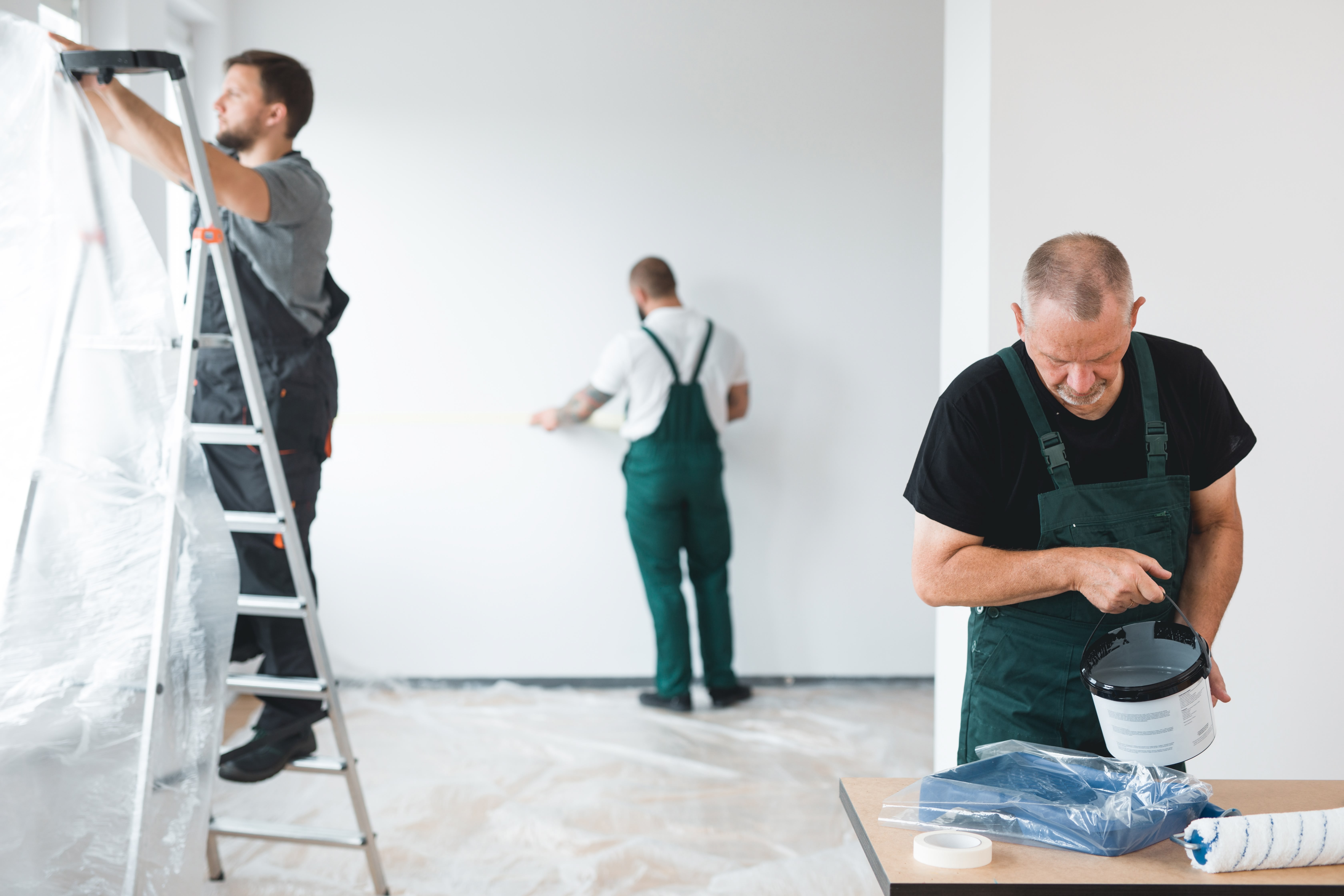 Workers painting and finishing an interior construction space