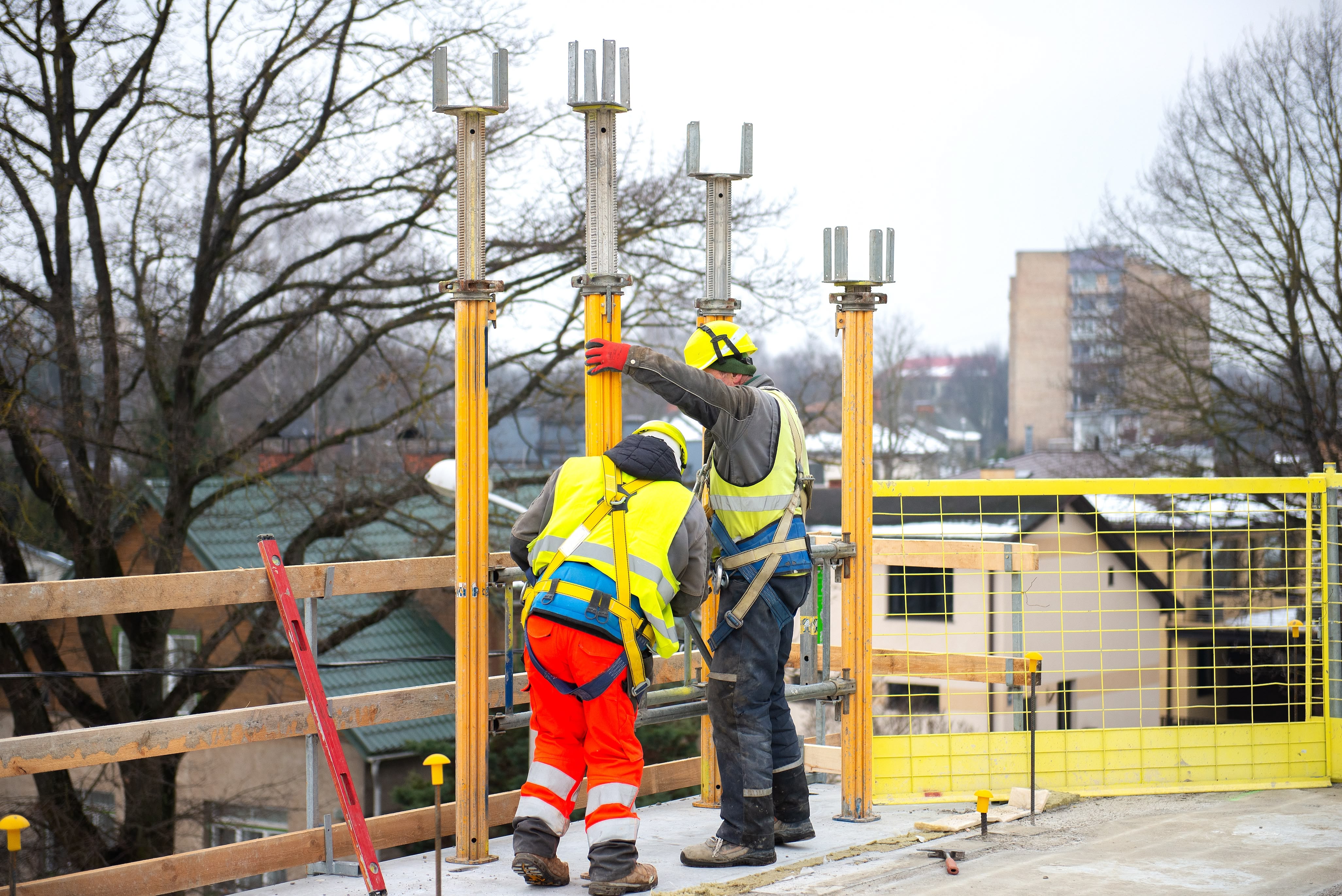 Construction workers on a rooftop installing shoring props
