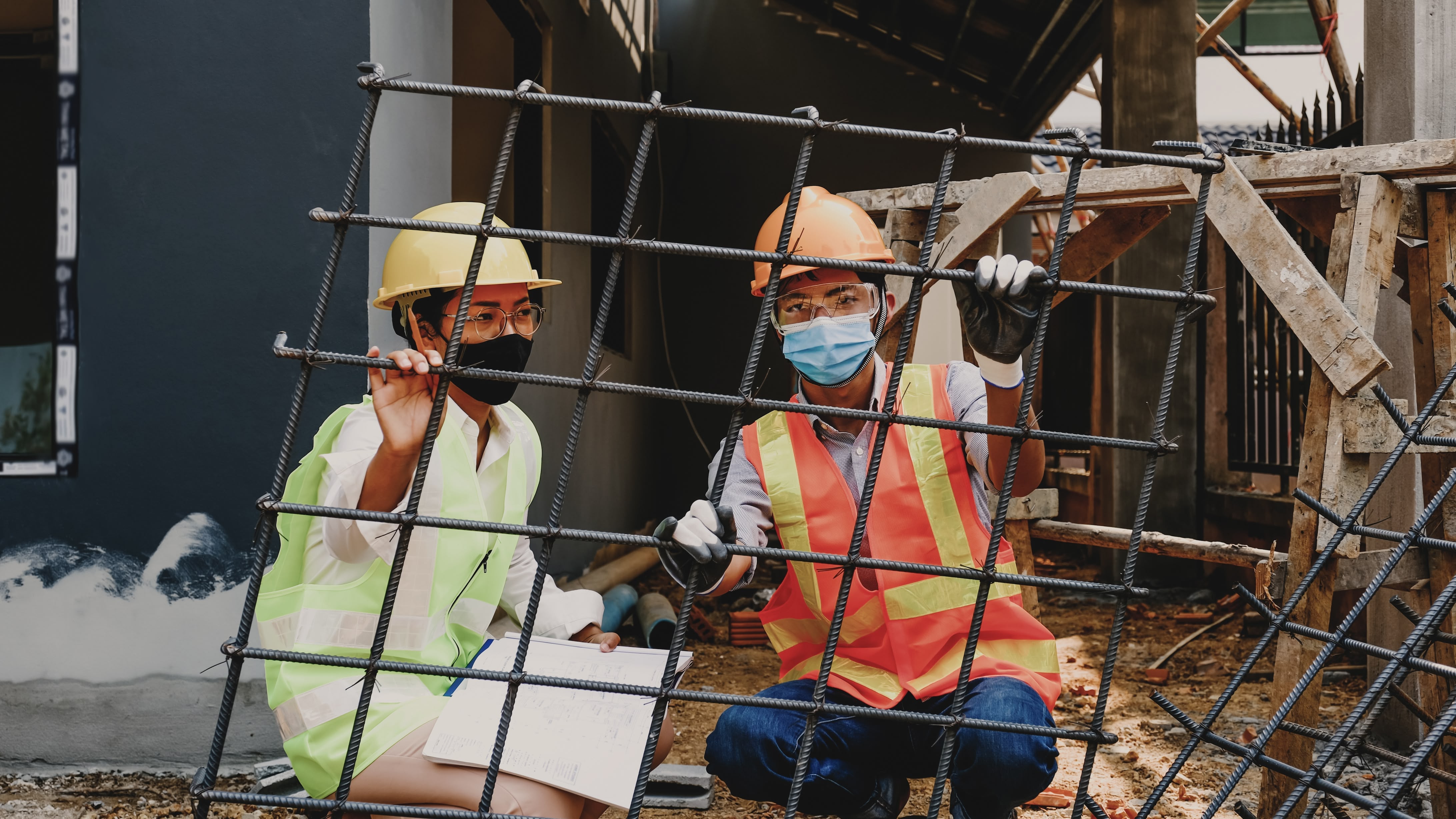 Two construction workers inspecting a rebar cage on a jobsite